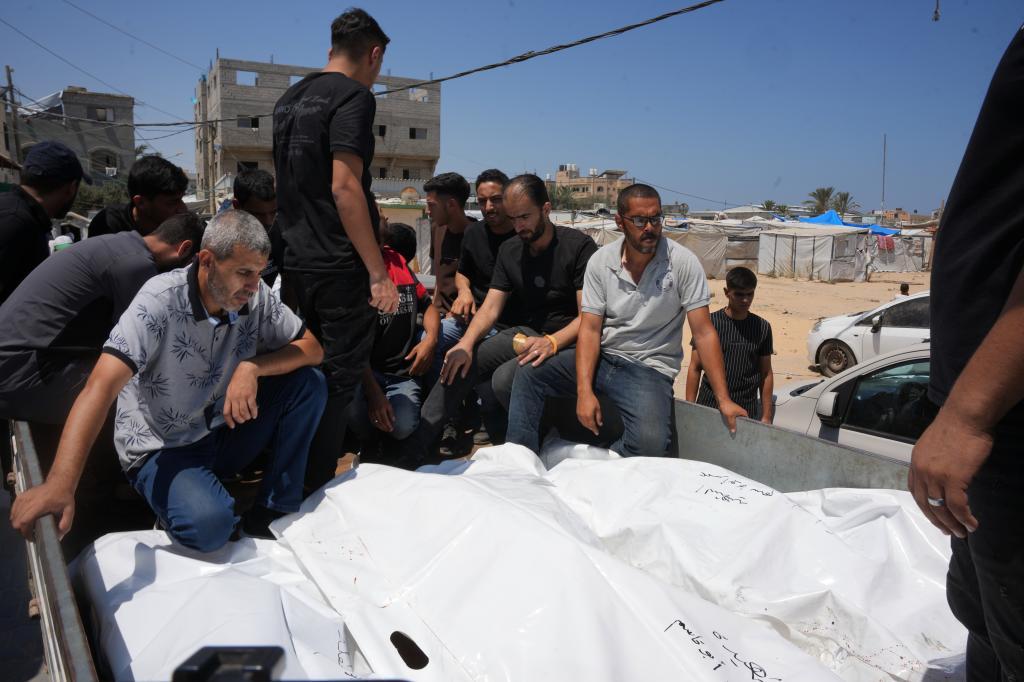 Palestinians carry the bodies of people killed in an Israeli military strike