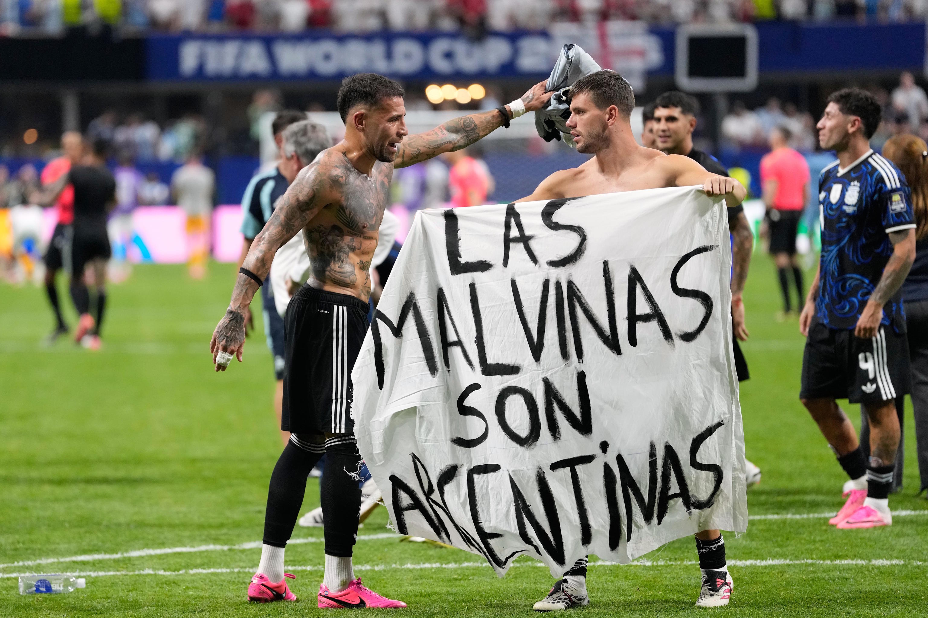 Argentina's Giovani Lo Celso holds a banner with the words "The Malvinas are Argentine", referring to the Falkland Islands.