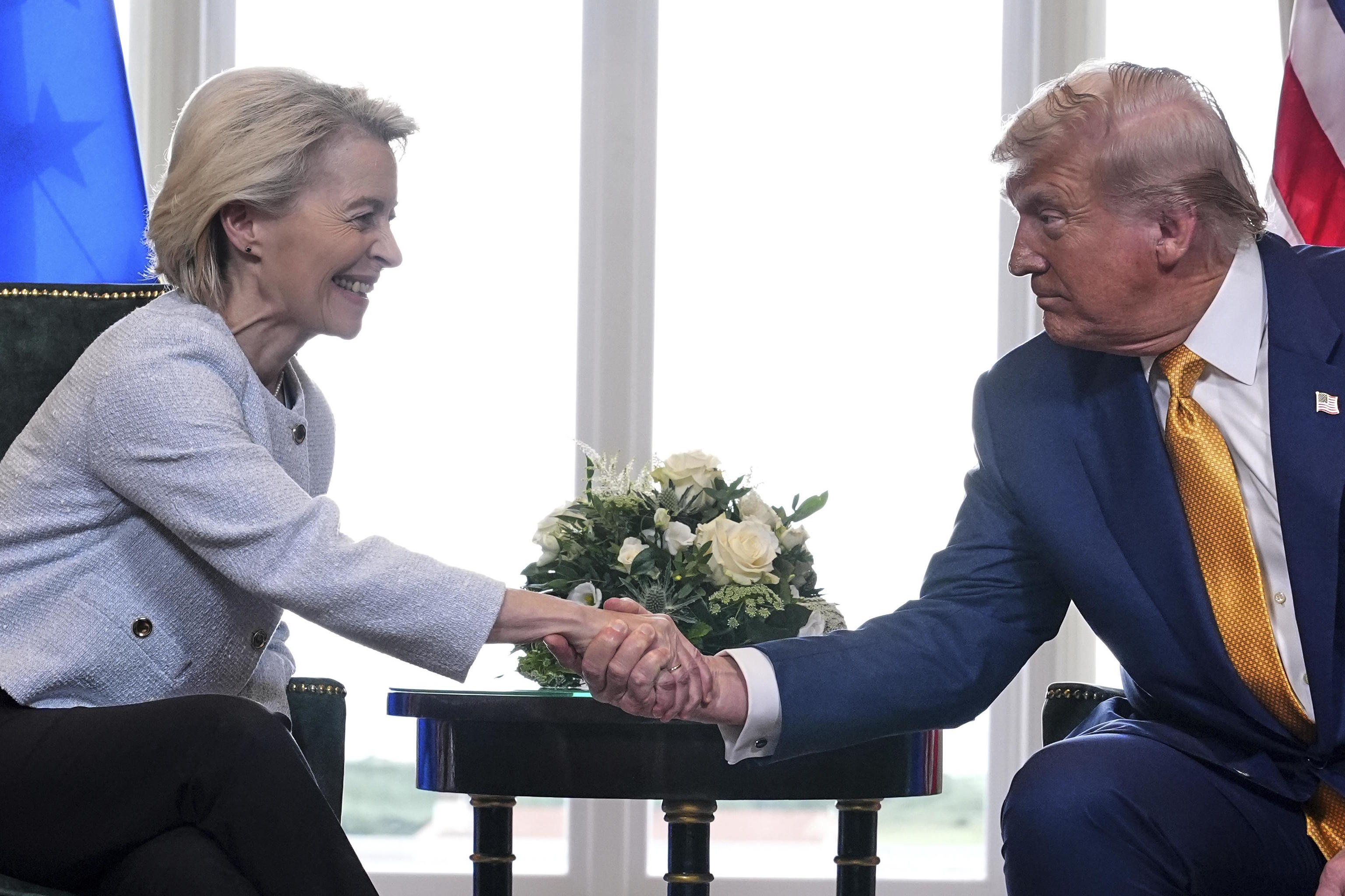 Donald Trump and Ursula von der Leyen shake hands.