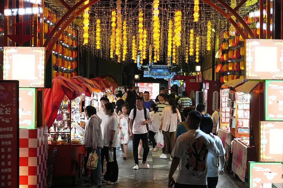 Several people walking on a street in Beijing.
