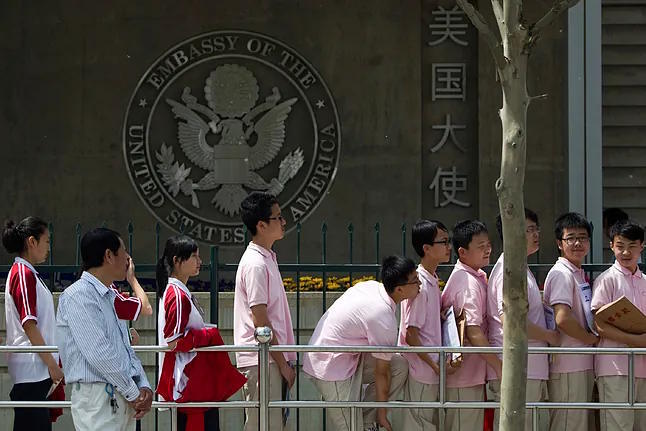 Chinese students wait outside the US embassy for their visa interviews in Beijing.