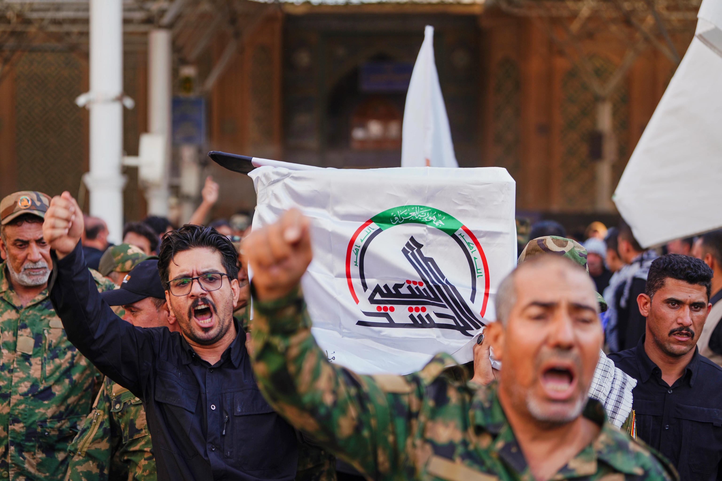 Mourners carry a coffin draped with a cloth bearing the emblem of Iraq's Popular Mobilization Forces during a funeral.