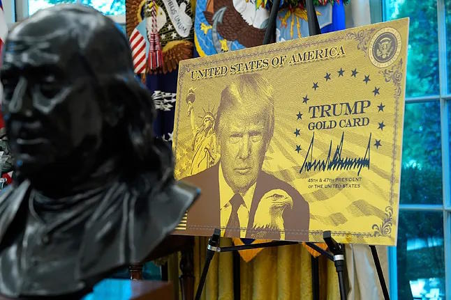 A poster featuring the "Trump Gold Card" is displayed in the Oval Office, last September.