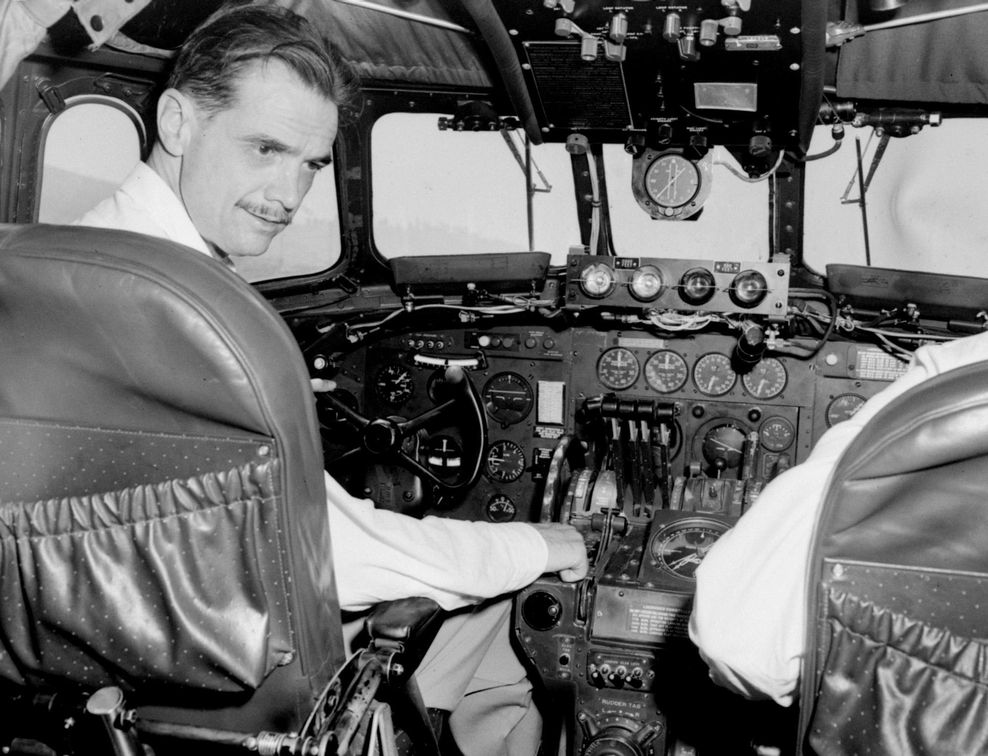 File photo (October 1947) of the aviation and film tycoon in the cockpit of an airplane.