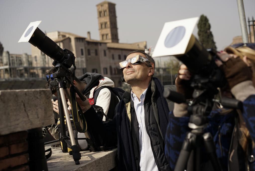 Photographers take images using a special filter during a solar eclipse