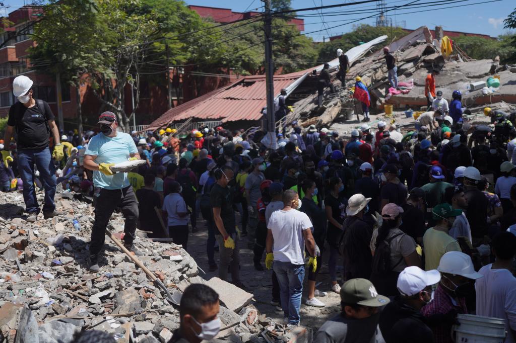 Residents clear debris in search of survivors the day after an earthquake struck Cali