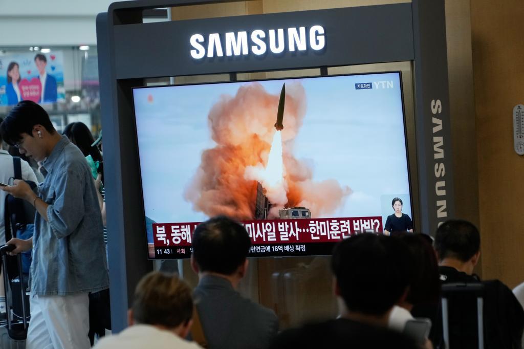 A TV screen shows a file image of North Korea's missile launch