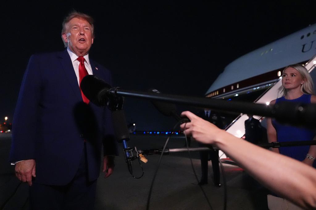 President Donald Trump talks to reporters after arriving on Air Force One