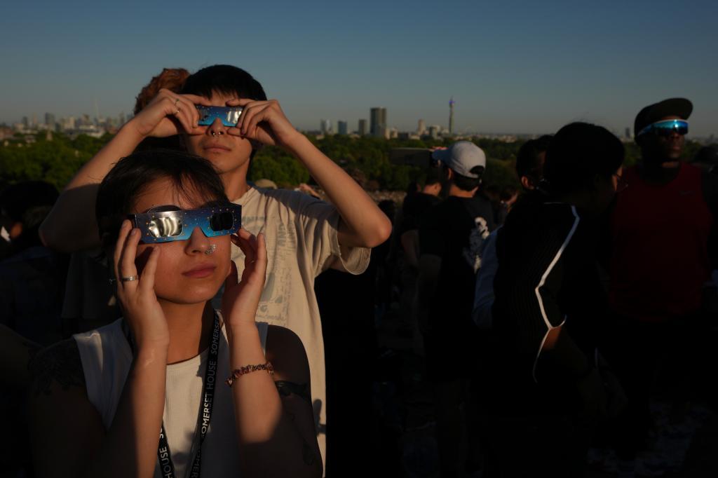 People watch the solar eclipse on Primrose Hill in London