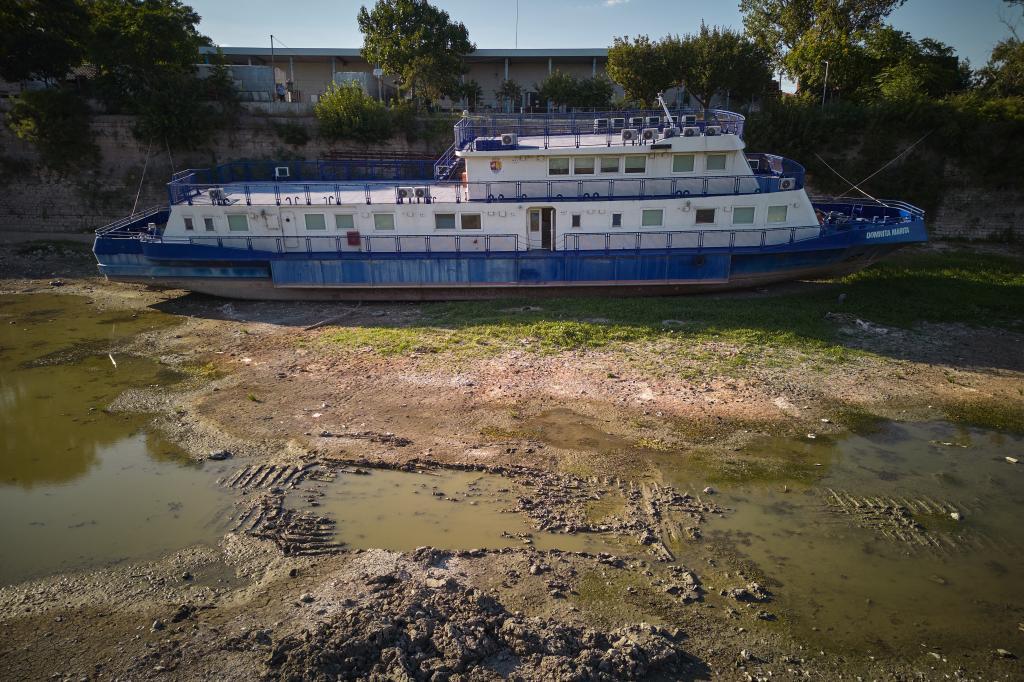 A ship is stranded on the bottom of a canal adjacent to the Danube River