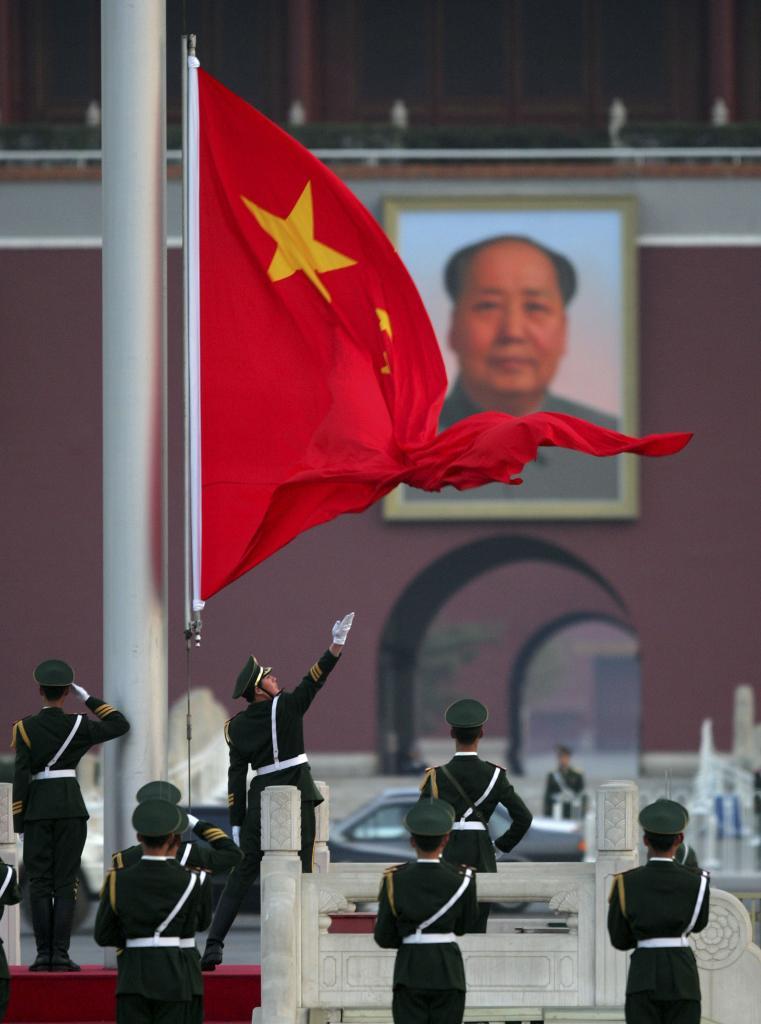 Police officers raise the Chinese flag in Tiananmen Square, Beijing