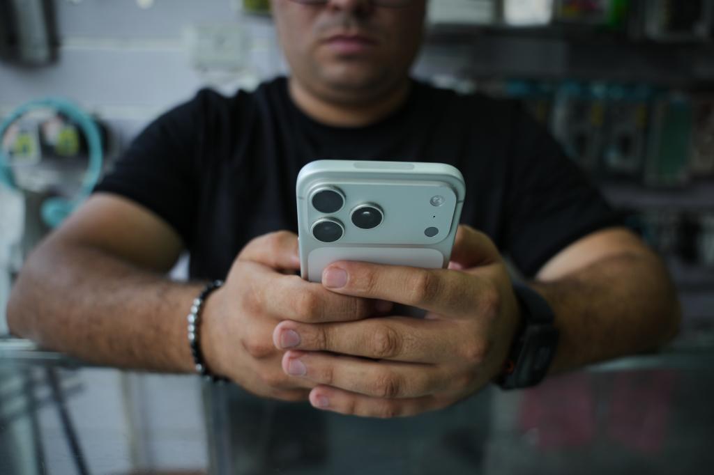 A man holds an iPhone 17 Pro.
