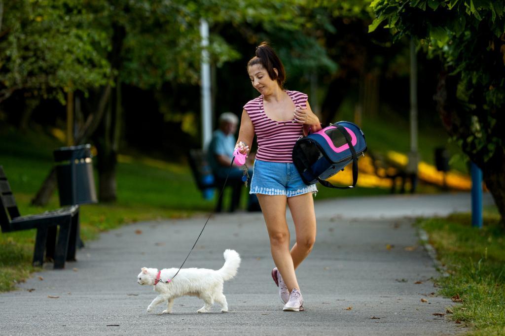 A woman walks with her cat.