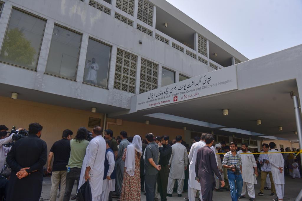 People gather outside a nursery in the gynecology ward following a fire at a hospital in Islamabad