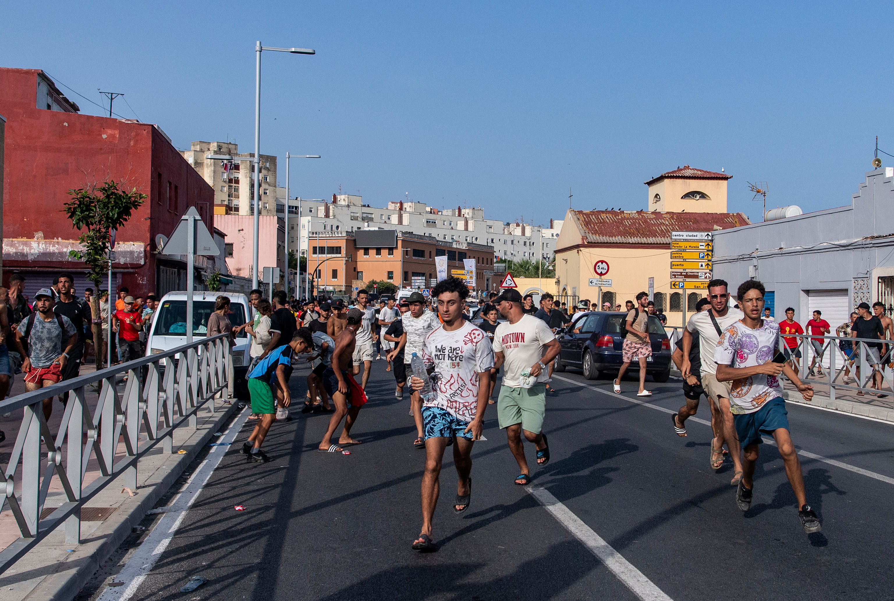 Migrants run from Spanish police officers after crossing from Morocco into the Spanish enclave of Ceuta.