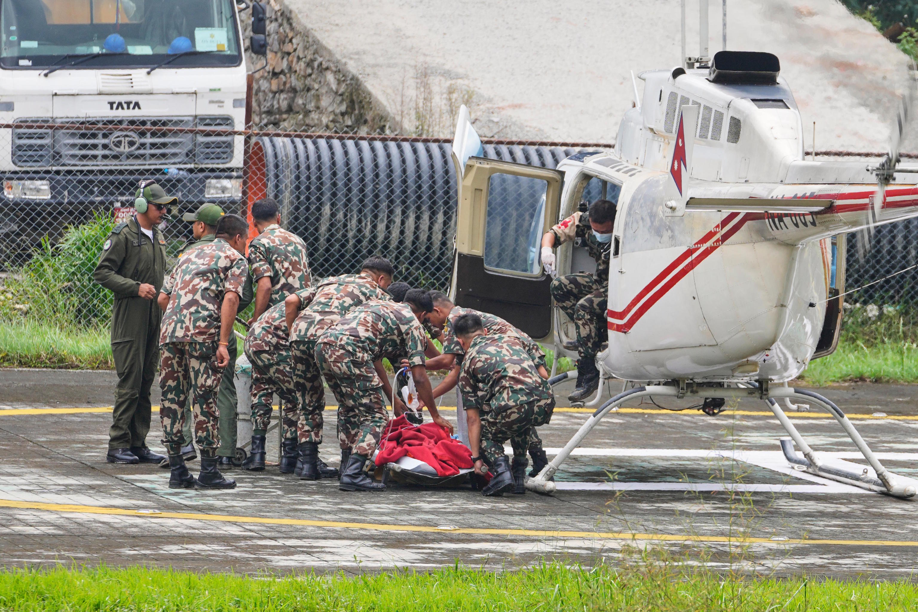 Nepal Army soldiers carry Kabir Maharjan to an ambulance after he was rescued.
