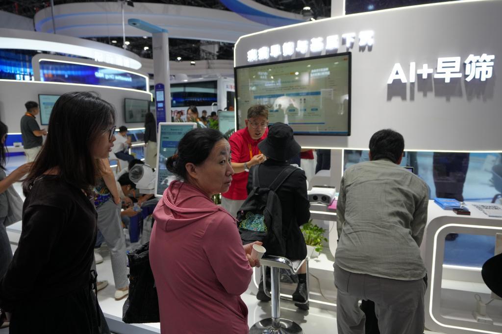 Visitors tour a booth promoting Chinese traditional treatment using AI technology