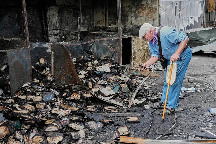A man searches through burnt books following a Russian missile attack in Ukraine.