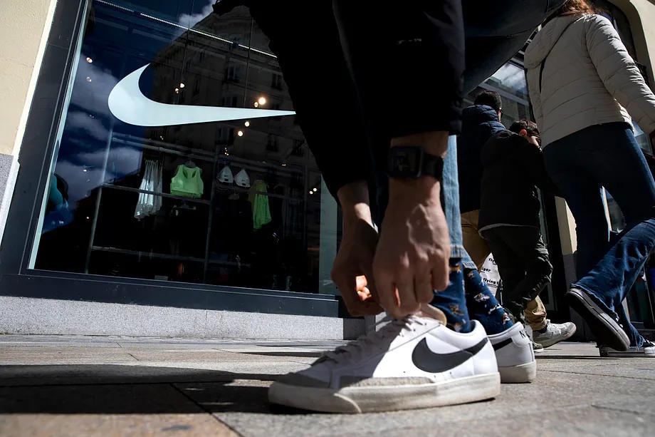 A customer with Nike sneakers in front of a brand store.