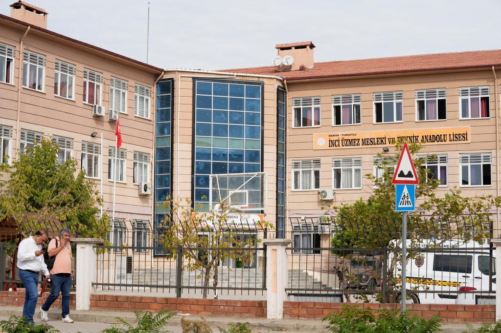 People walk past a vocational and technical high school in the Turgutlu district of Manisa province