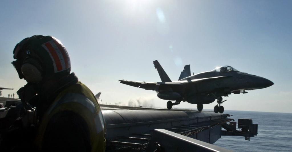 Image of an F-18 Hornet aircraft taking off from the deck of the aircraft carrier USS Harry S. Truman.