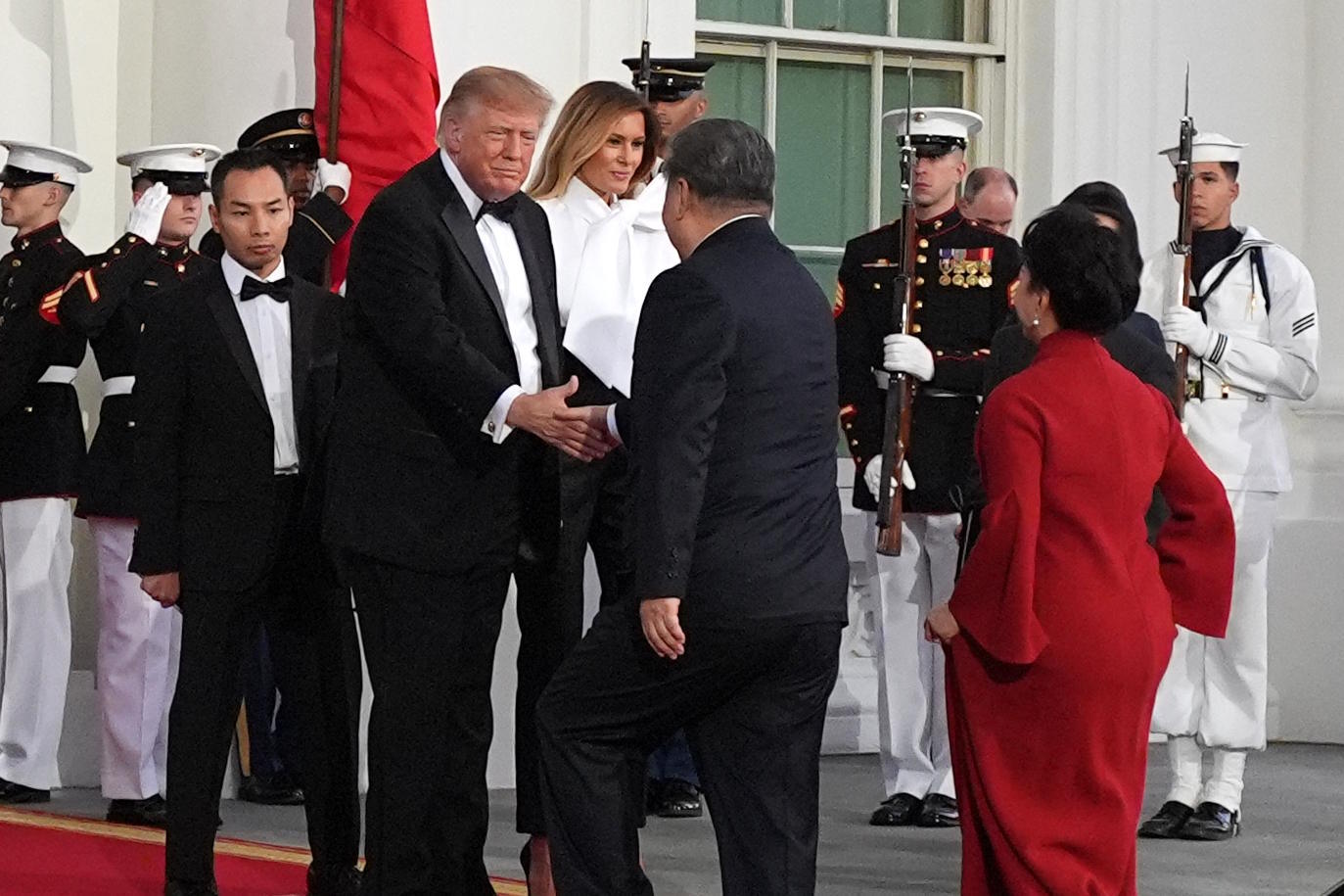 President Donald Trump and first lady Melania Trump walk with China's President Xi Jinping and his wife Peng Liyuan.