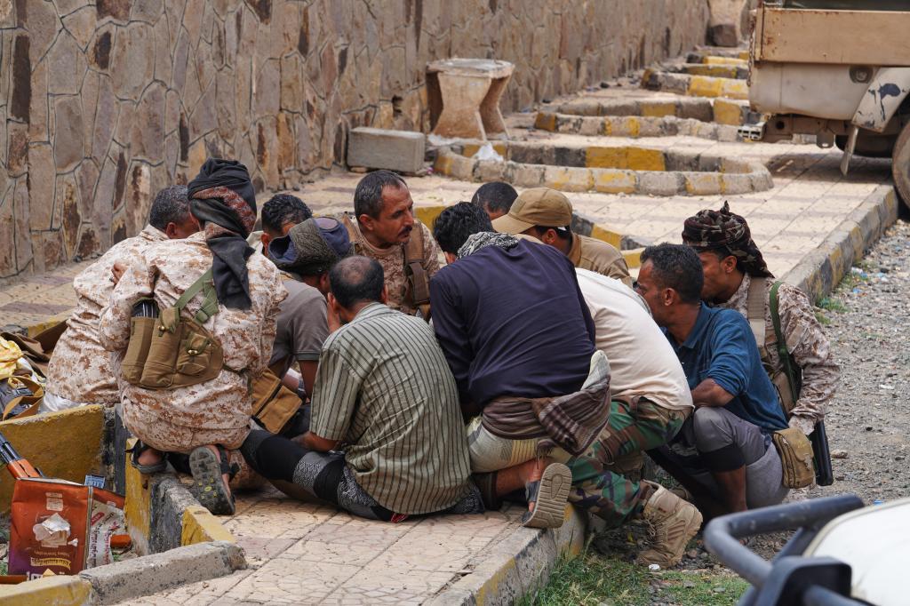 Yemeni soldiers eat at a military position in the Al-Kadha