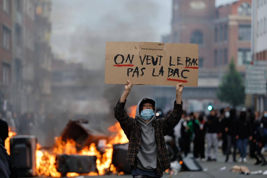 A students holds a board reading, "we want the BAC (High School Diploma) Not the BAC (Anti-criminality units)" during a protest to demand more resources at school, in Lille