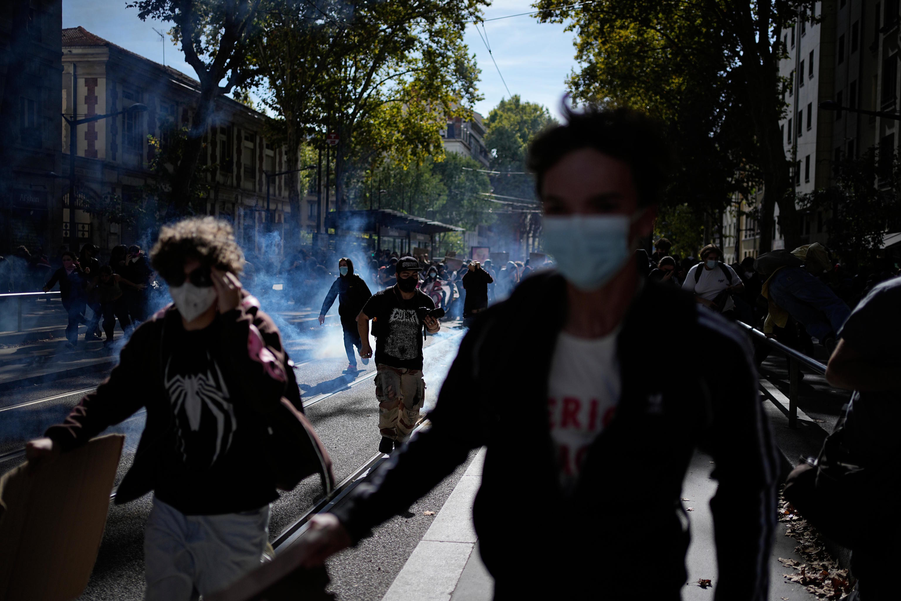 Students run in the teargas during a protest in Lyon, France.