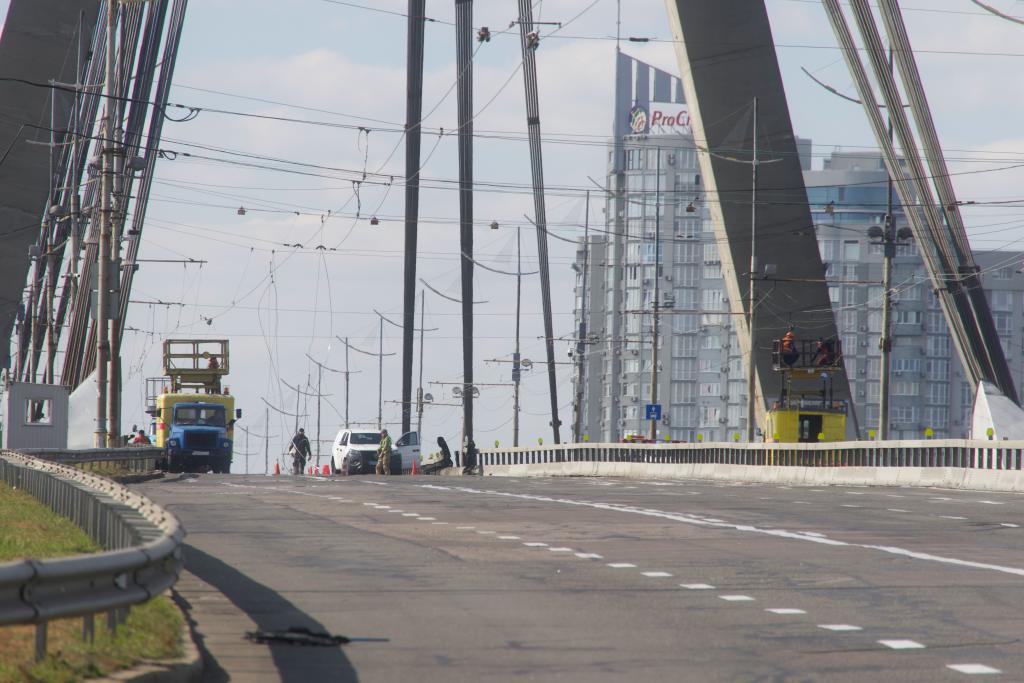 Police officers inspect the site of a Russian drone strike on the Northern Bridge across the Dnipro River in Kyiv