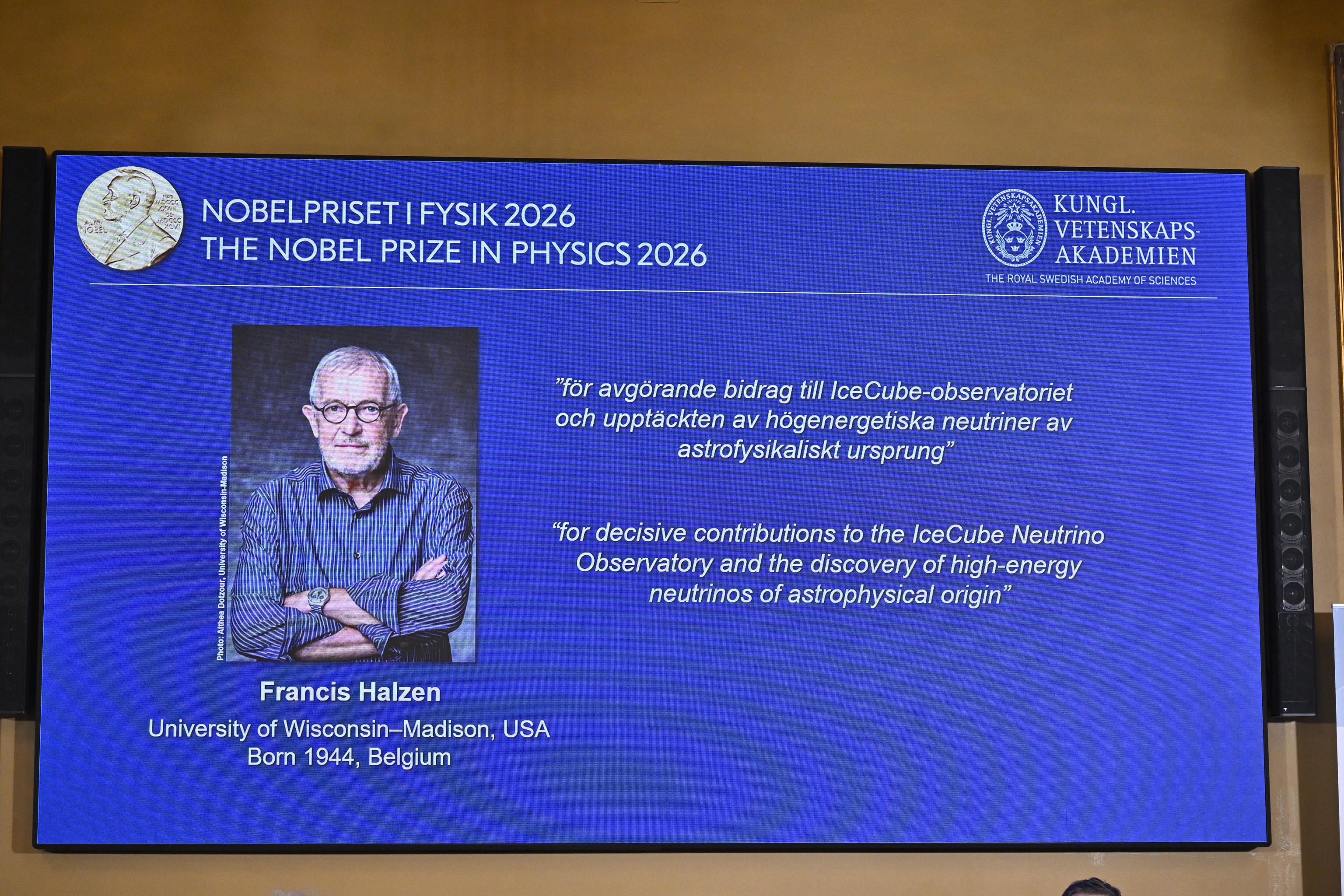 A portrait of Francis Halzen is shown on the screen during the announce of the recipient of the 2026 Nobel Prize in Physics.