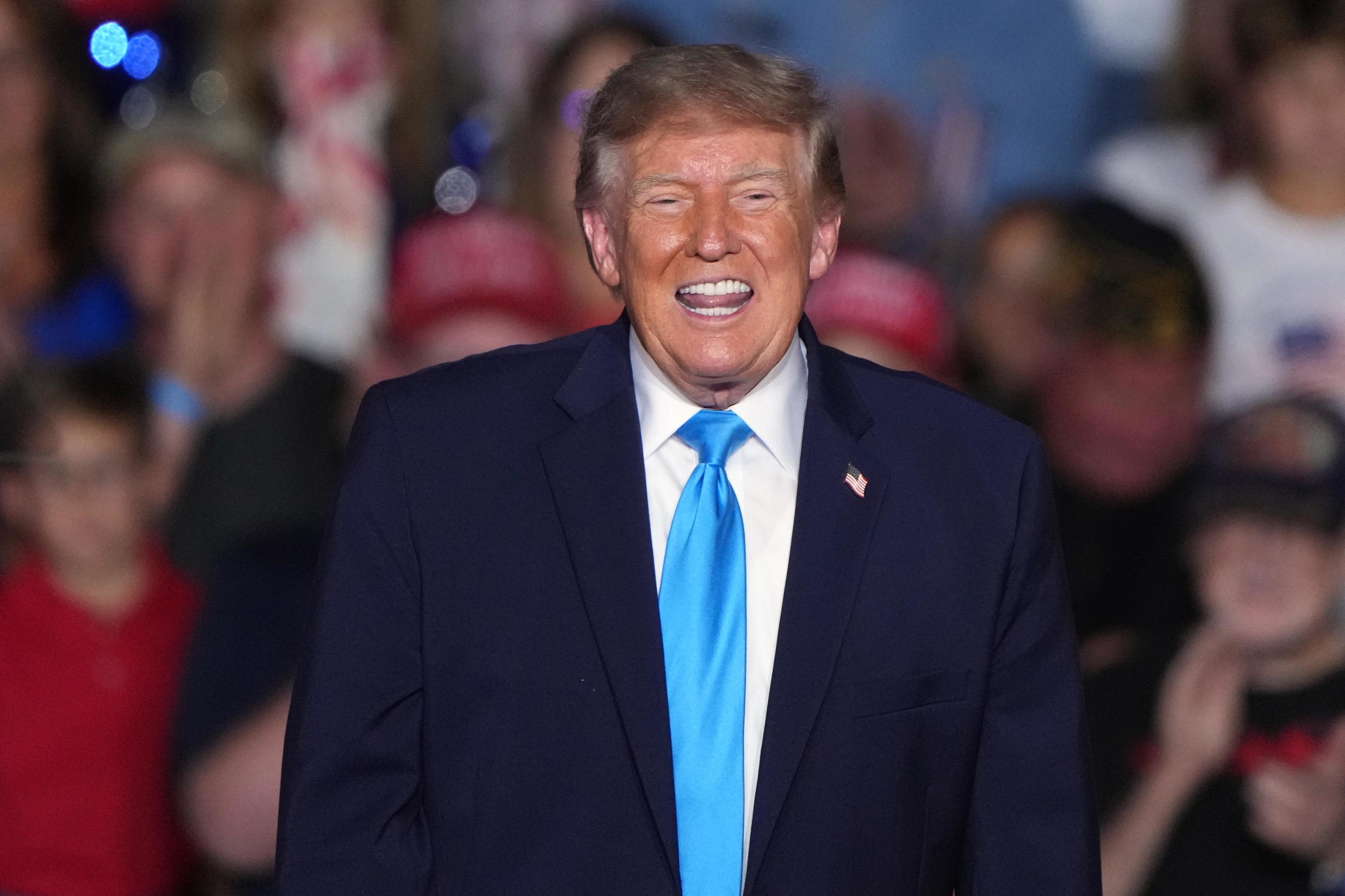President Donald Trump smiles at a campaign rally.
