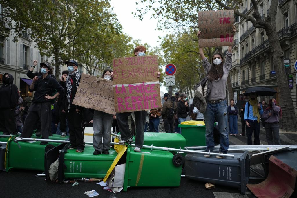 Students with a board reading : 'Youth speaks. The police repress." stand in front of Sciences Po university