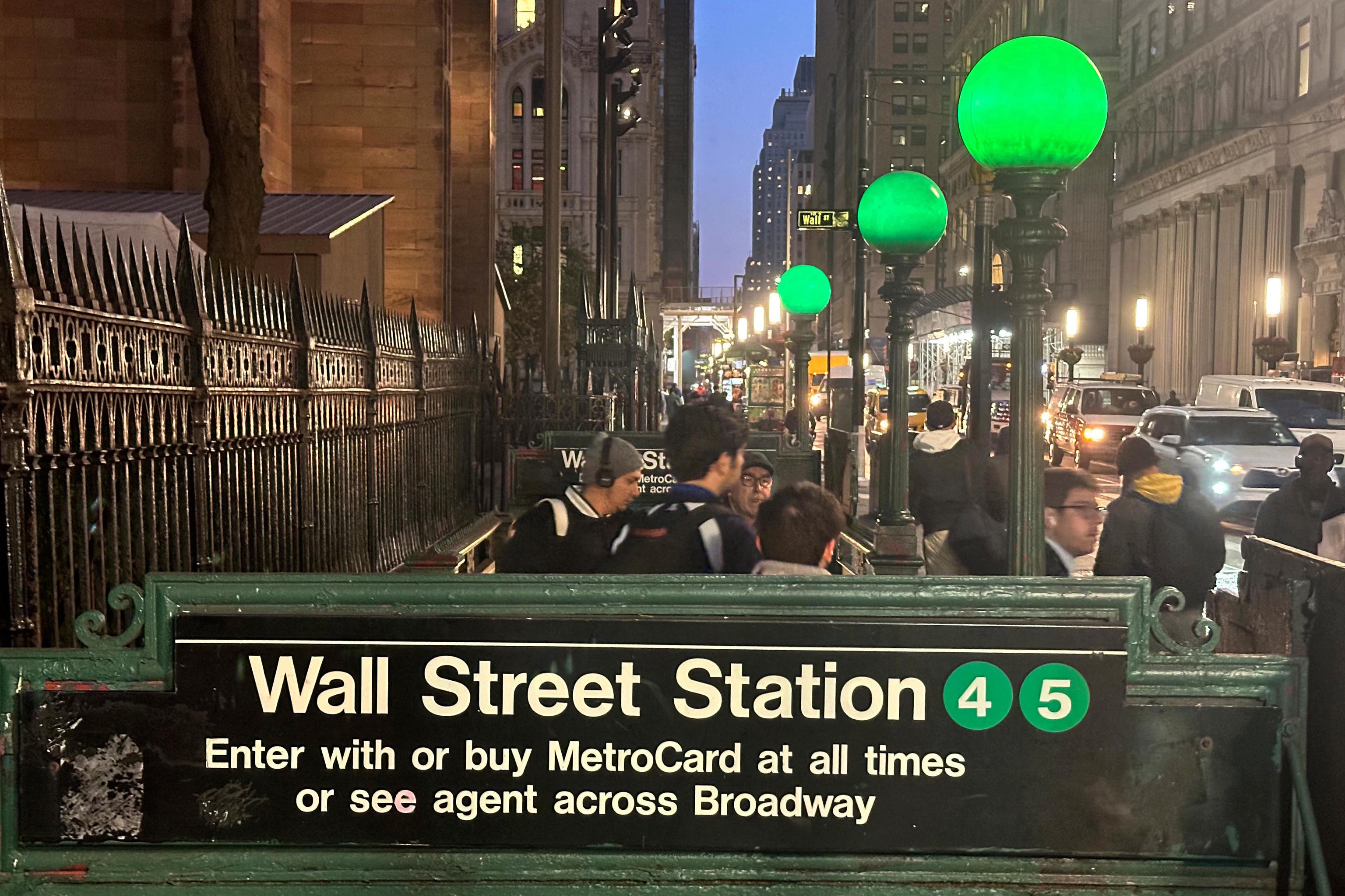 Commuters emerge from a Wall Street subway station in New York's Financial District.