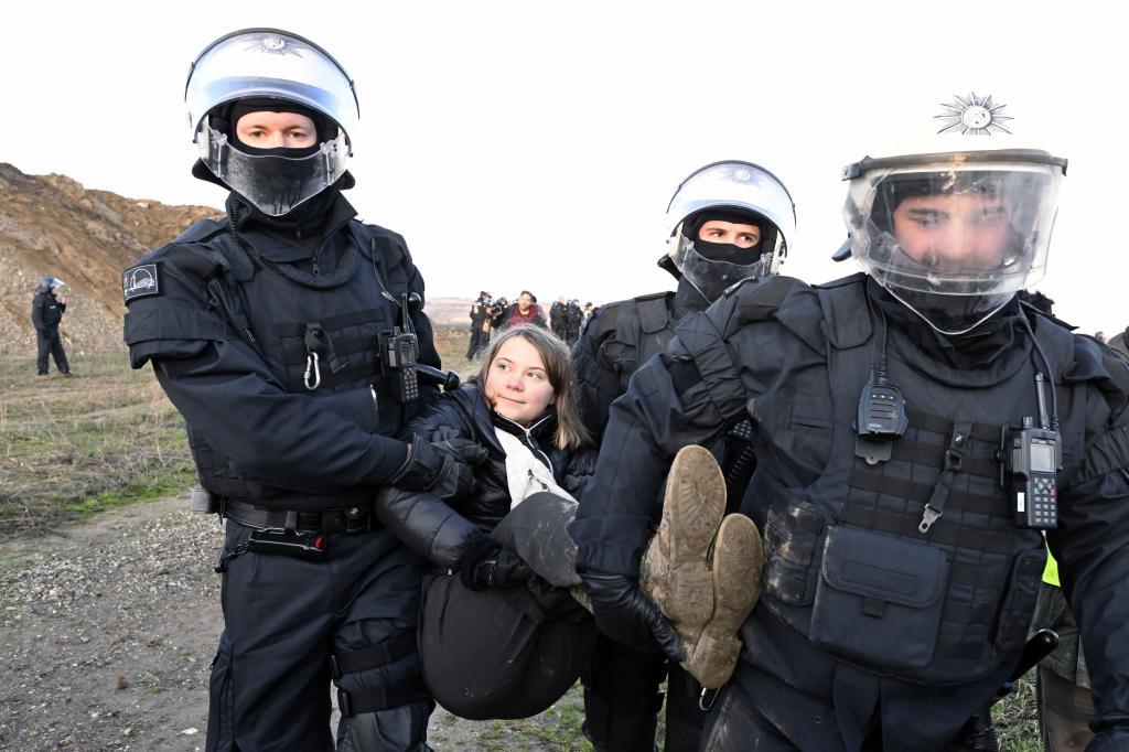 Police officers carry Swedish climate activist Greta Thunberg