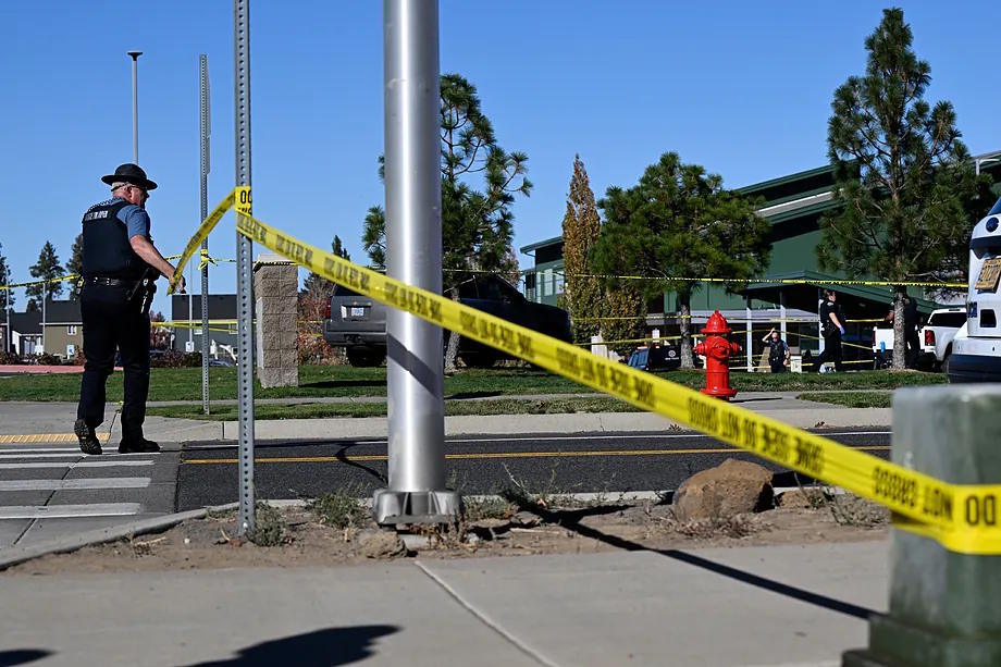 An officer places police tape in front of Silver Rail Elementary School, where the shooting took place.