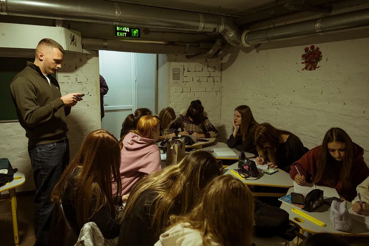Ukrainian children study in the basement during a drone alert at the Miguel de Cervantes school in Kiev.