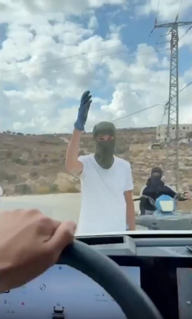 Masked Israeli settlers confront the occupants of a car driven by Israeli activists in the village of Taybe.