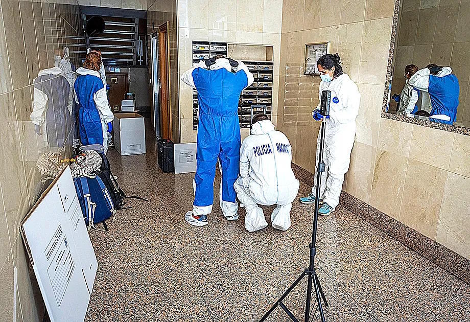 Forensic police officers collect evidence at the scene on October 14.