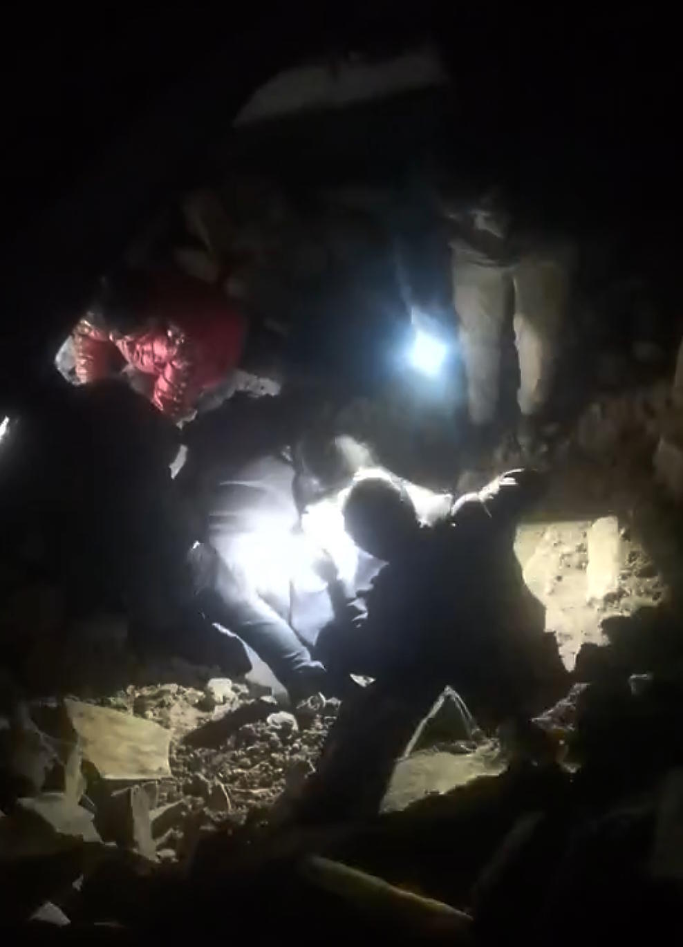 people try to rescue residents trapped in a collapsed house.
