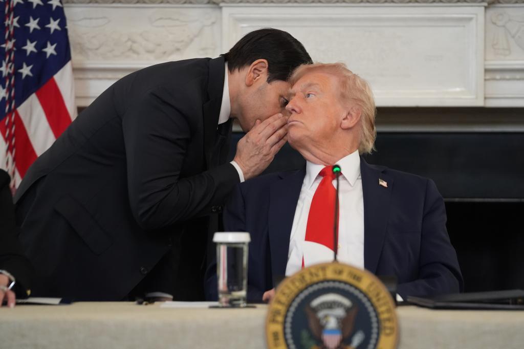 Secretary of State Marco Rubio whispers to President Donald Trump