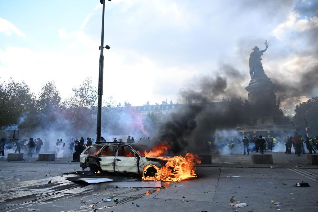 A car burns at Place de La Republique during a protest against rising living costs in Paris